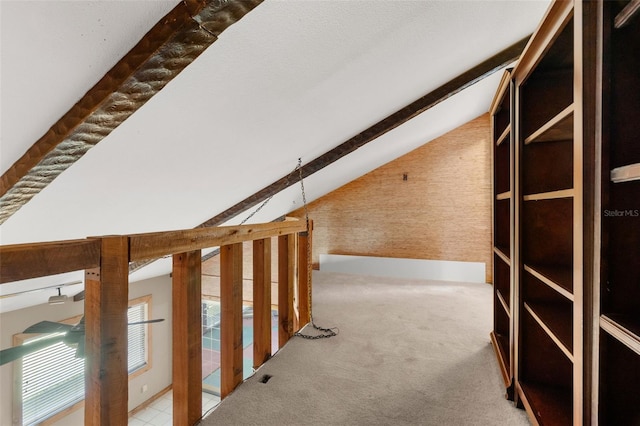 interior space featuring lofted ceiling with beams and carpet floors