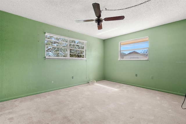 carpeted empty room featuring a textured ceiling and ceiling fan