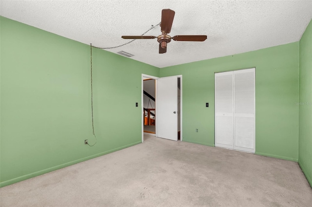 unfurnished bedroom with light carpet, a closet, a textured ceiling, and ceiling fan