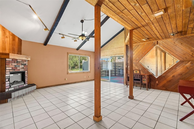 unfurnished living room with wood walls, light tile patterned flooring, and ceiling fan