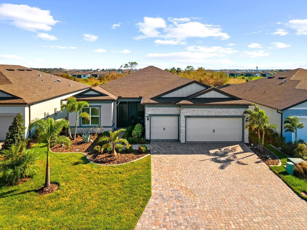 ranch-style house with a garage and a front lawn