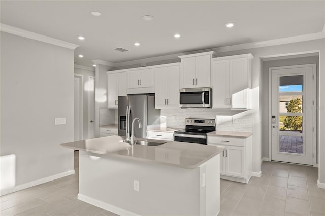 kitchen with stainless steel appliances, white cabinetry, a center island with sink, and sink