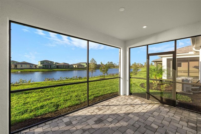 unfurnished sunroom featuring a water view