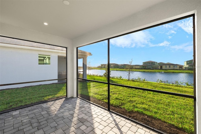 unfurnished sunroom featuring a water view