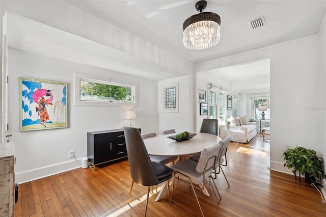 dining room featuring crown molding, a chandelier, and hardwood / wood-style floors