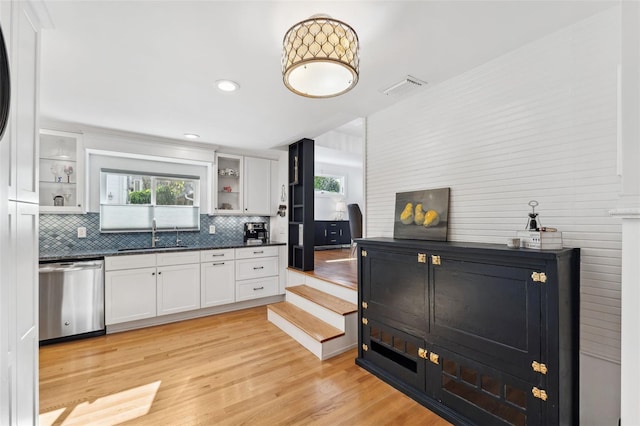 kitchen with white cabinetry, dishwasher, sink, and tasteful backsplash