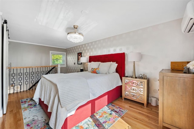 bedroom featuring wood-type flooring, a chandelier, and a wall unit AC