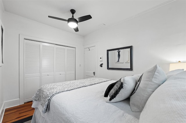 bedroom featuring ceiling fan, dark hardwood / wood-style flooring, and a closet