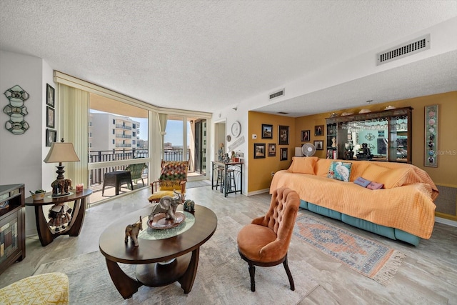 living room with a textured ceiling and floor to ceiling windows