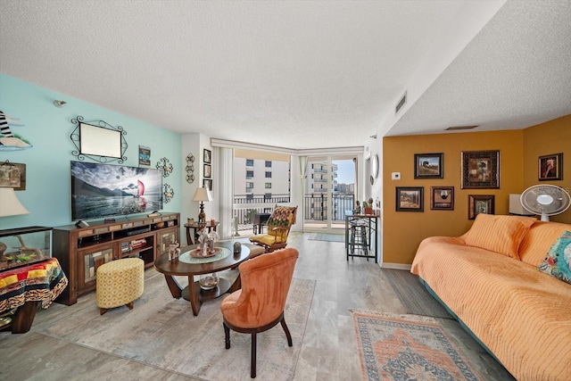 living room featuring a wall of windows and a textured ceiling