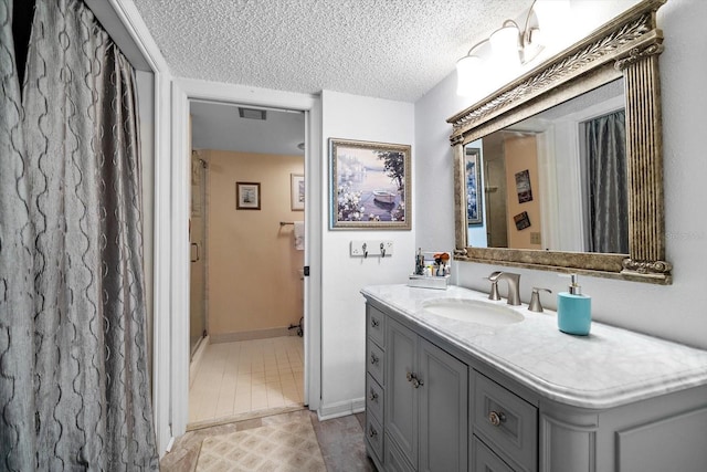 bathroom featuring vanity, a textured ceiling, and tile patterned floors