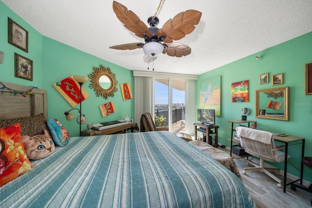 bedroom featuring a textured ceiling, access to exterior, and ceiling fan