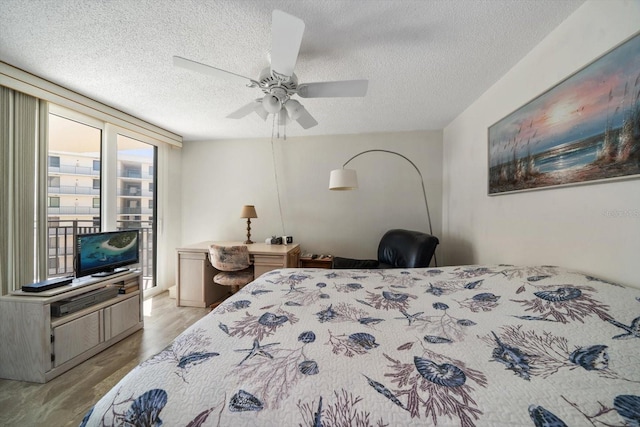 bedroom featuring light hardwood / wood-style flooring, a textured ceiling, and ceiling fan