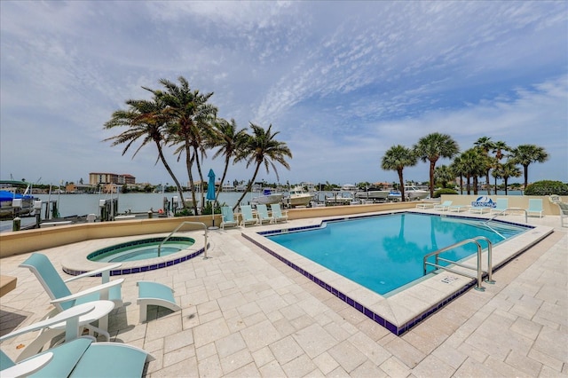 view of swimming pool featuring a water view, a patio area, and a community hot tub