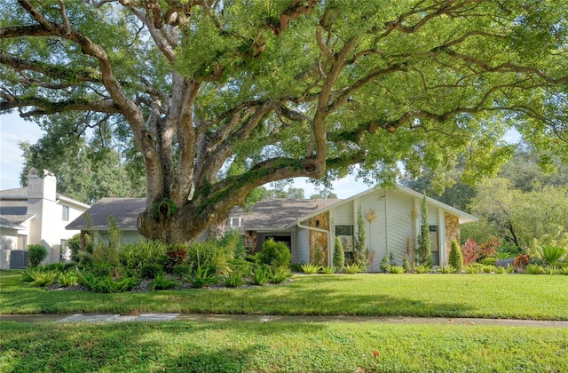 view of front facade with a front yard and central air condition unit