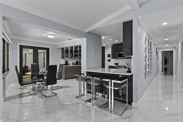 kitchen with a breakfast bar, kitchen peninsula, and ornamental molding