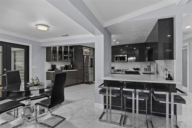 kitchen featuring kitchen peninsula, backsplash, a textured ceiling, stainless steel appliances, and sink