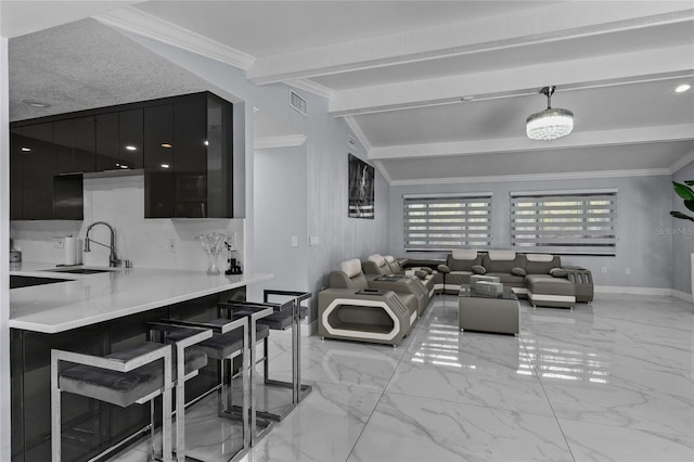 living room with beam ceiling, crown molding, and sink