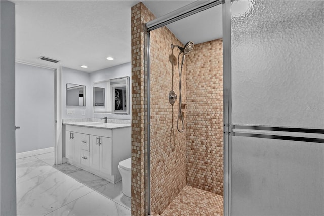 bathroom with vanity, a shower with shower door, and toilet