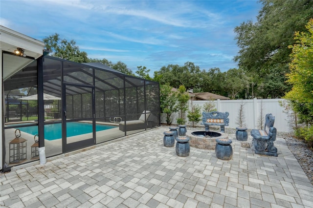 view of patio featuring a fenced in pool, glass enclosure, and a fire pit