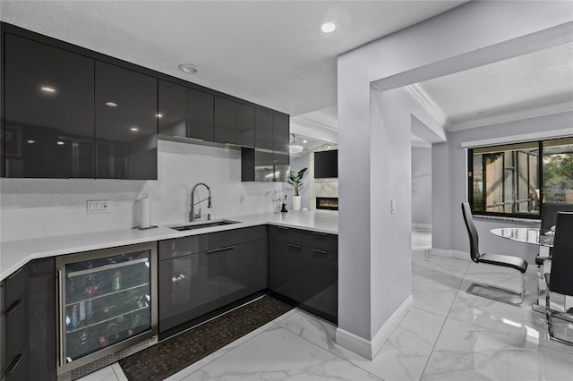 kitchen featuring sink, beverage cooler, crown molding, a textured ceiling, and decorative backsplash