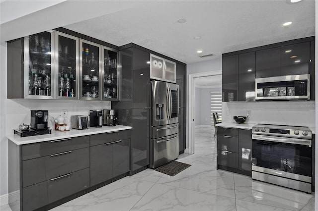 kitchen featuring backsplash, stainless steel appliances, and a textured ceiling