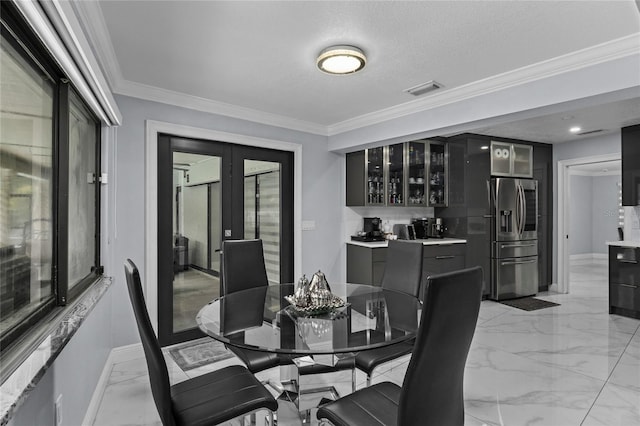 dining space featuring bar area, french doors, a textured ceiling, and crown molding