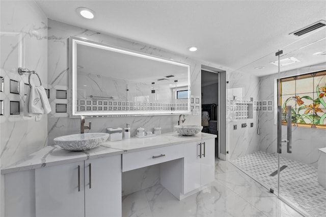 bathroom with a textured ceiling, vanity, and walk in shower