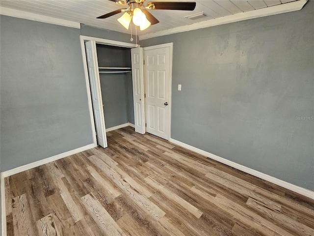 unfurnished bedroom with wood ceiling, ceiling fan, light wood-type flooring, ornamental molding, and a closet