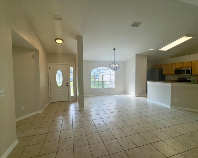 tiled foyer with a notable chandelier and vaulted ceiling