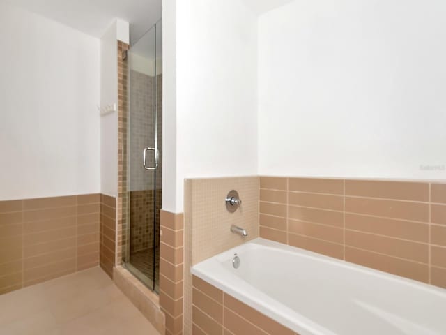 bathroom featuring plus walk in shower and tile patterned floors