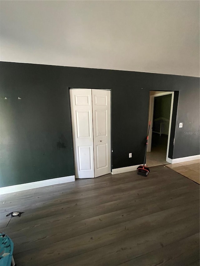 unfurnished room with dark hardwood / wood-style flooring