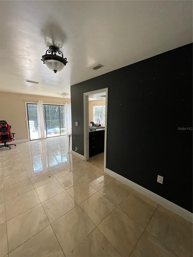 unfurnished room featuring sink and light tile patterned floors