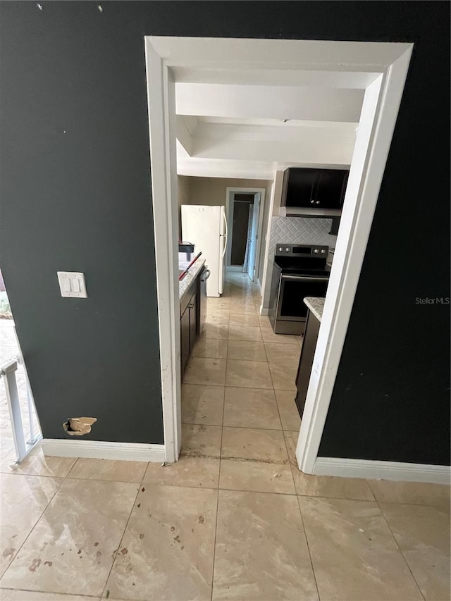 kitchen with white fridge, stainless steel range with electric cooktop, and backsplash