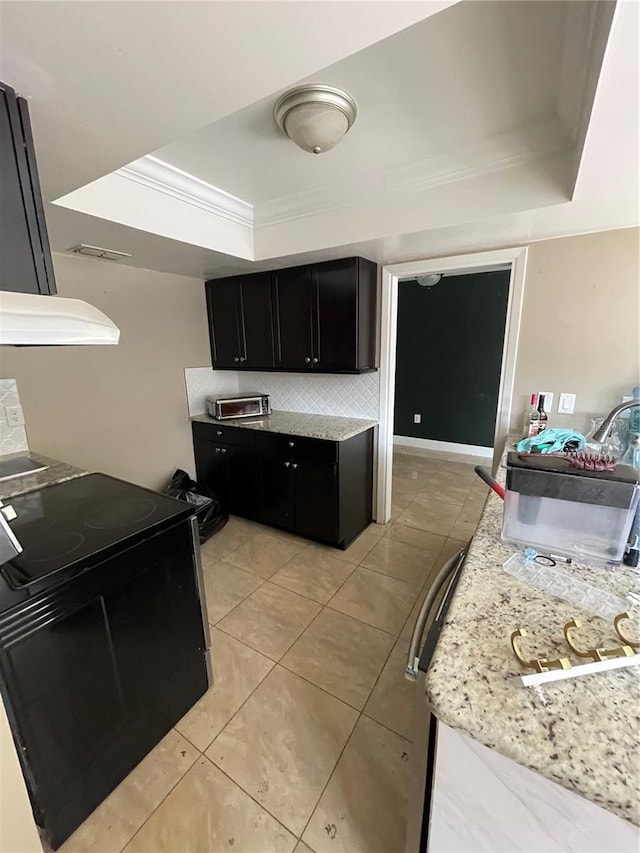 kitchen featuring backsplash, a tray ceiling, black / electric stove, ornamental molding, and light tile patterned floors