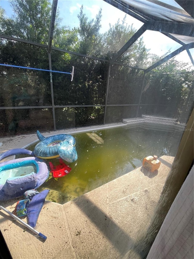 view of swimming pool with a patio and a lanai