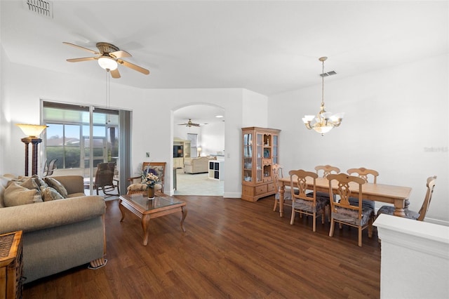 living room with dark wood-type flooring and ceiling fan with notable chandelier