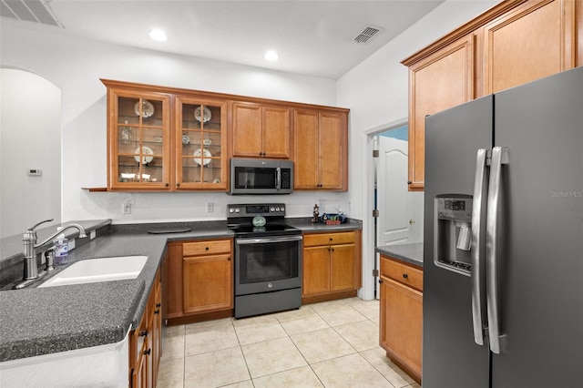 kitchen with light tile patterned flooring, stainless steel appliances, and sink