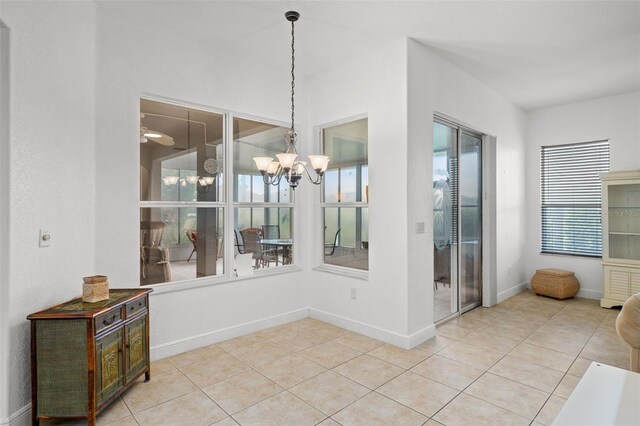 tiled dining room with an inviting chandelier