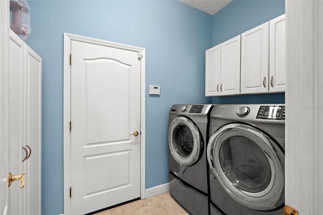 clothes washing area featuring cabinets, independent washer and dryer, and light tile patterned floors