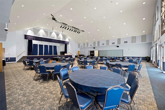 dining area featuring carpet floors and high vaulted ceiling