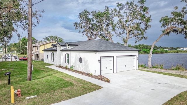 view of front of property featuring a water view, a garage, and a front lawn