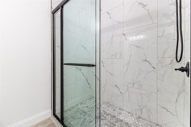 bathroom with an enclosed shower and hardwood / wood-style flooring