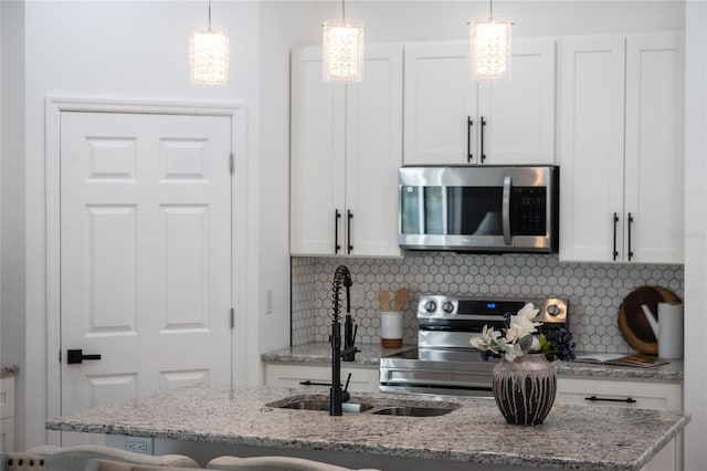 kitchen with white cabinets, decorative light fixtures, and appliances with stainless steel finishes