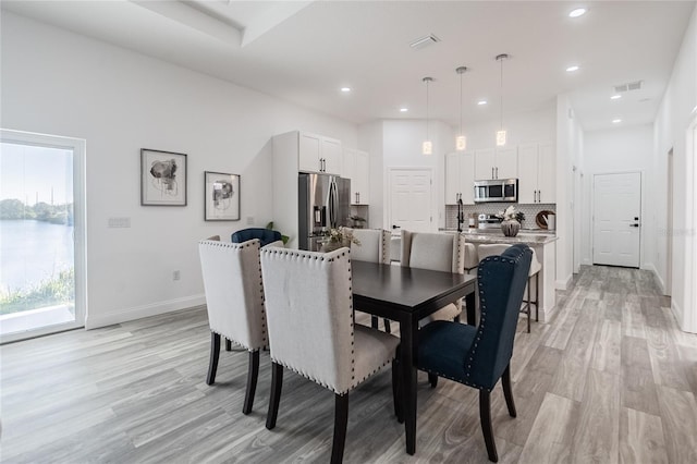 dining space with light wood-style floors, recessed lighting, visible vents, and baseboards