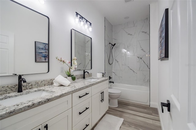 full bathroom with double vanity, bathing tub / shower combination, a sink, and wood finished floors