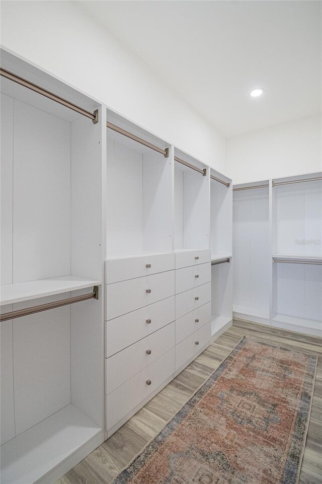 walk in closet with wood finished floors