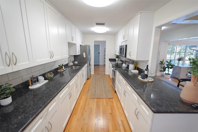 kitchen featuring white cabinets, appliances with stainless steel finishes, and tasteful backsplash