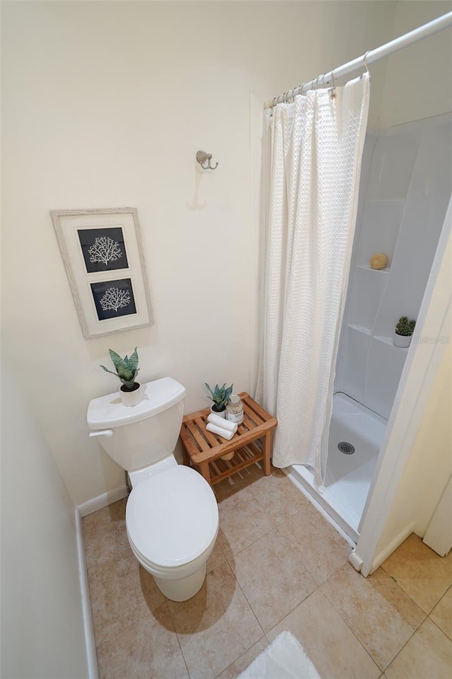 bathroom with tile patterned floors, curtained shower, and toilet