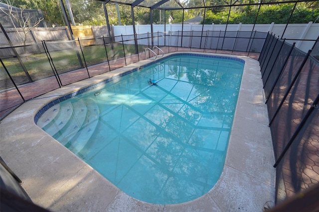 view of swimming pool featuring glass enclosure